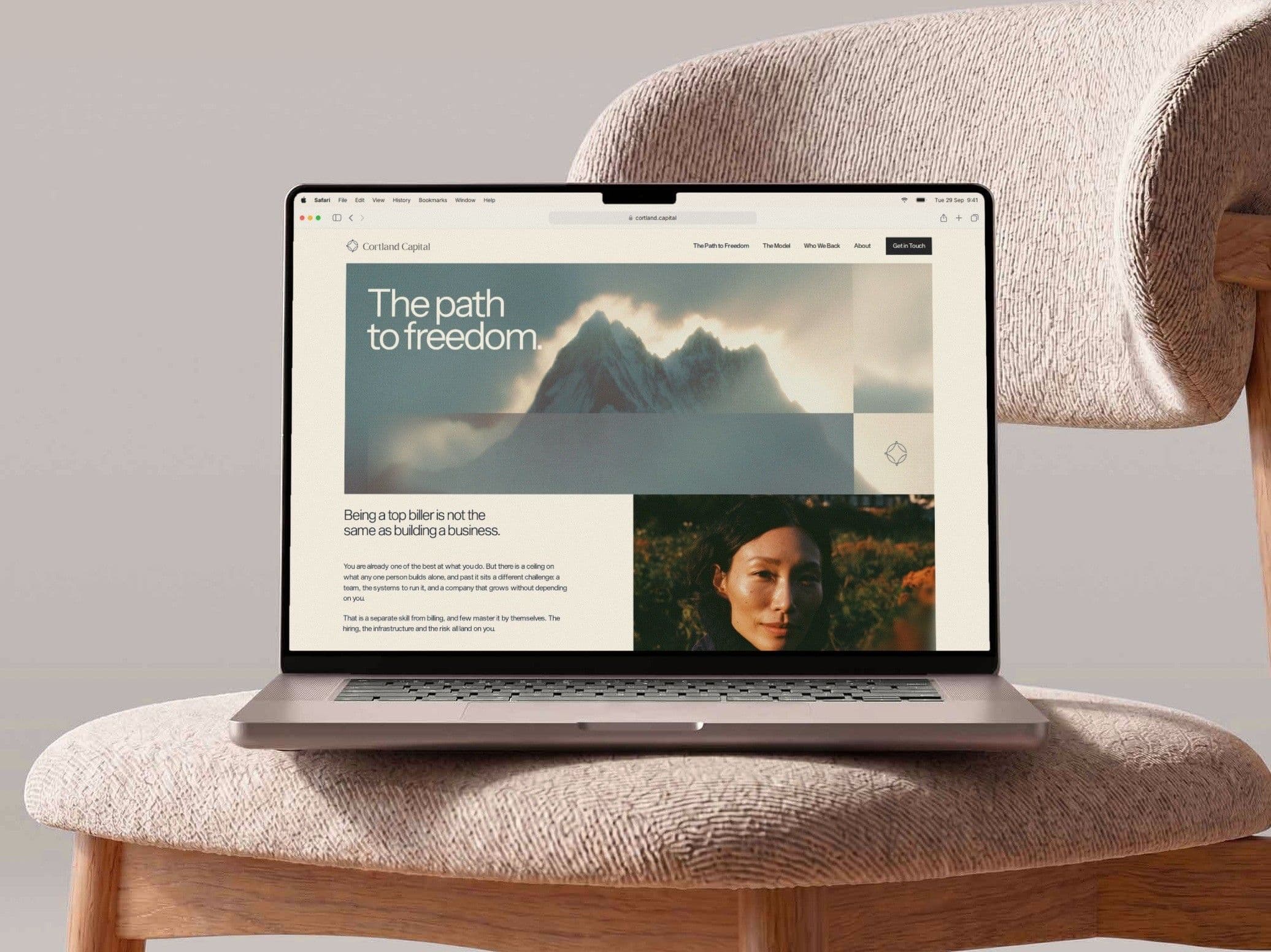 The Path to Freedom page on a MacBook resting on a bouclé chair