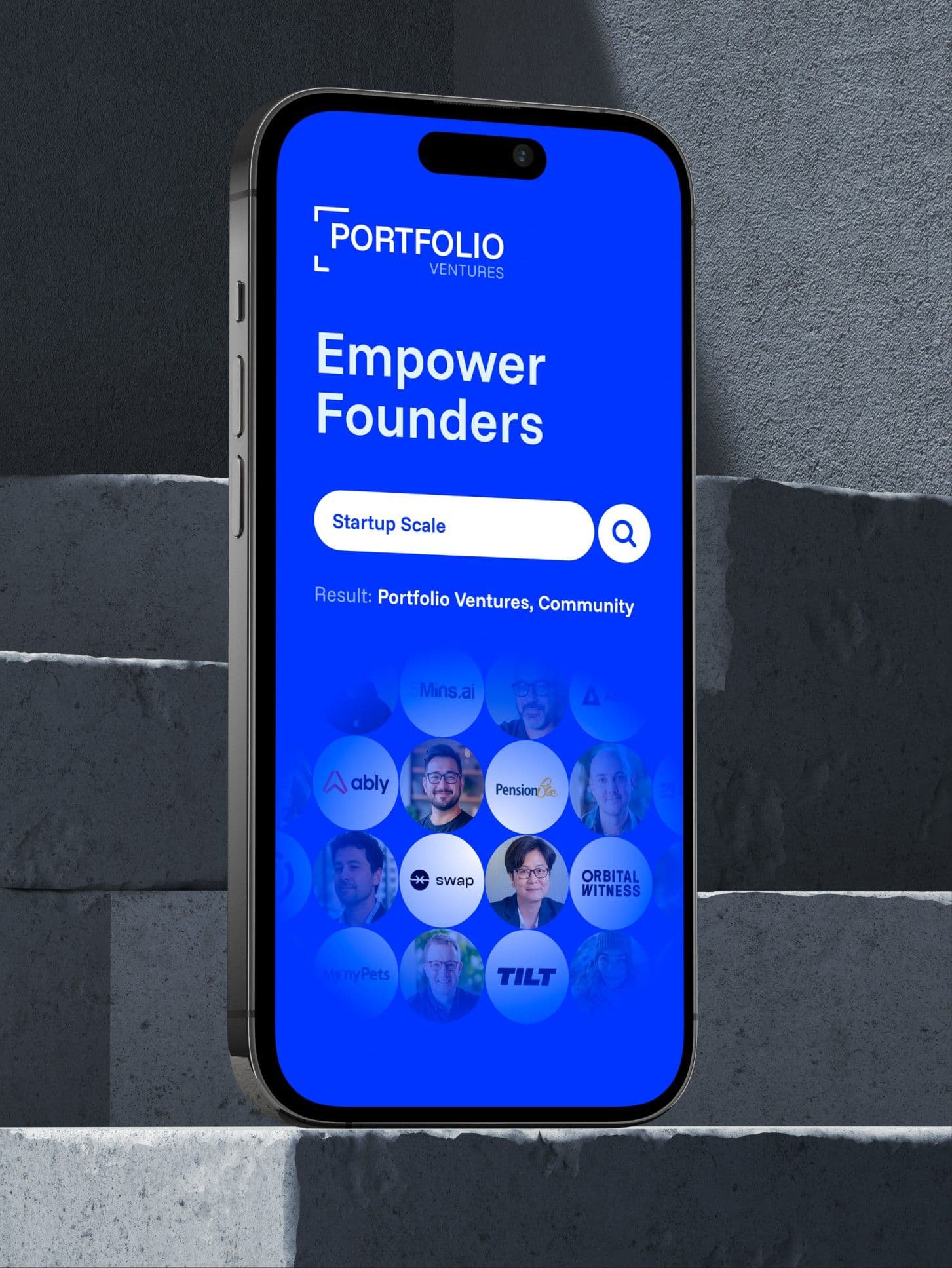 Empower Founders on a phone, stood on stone steps