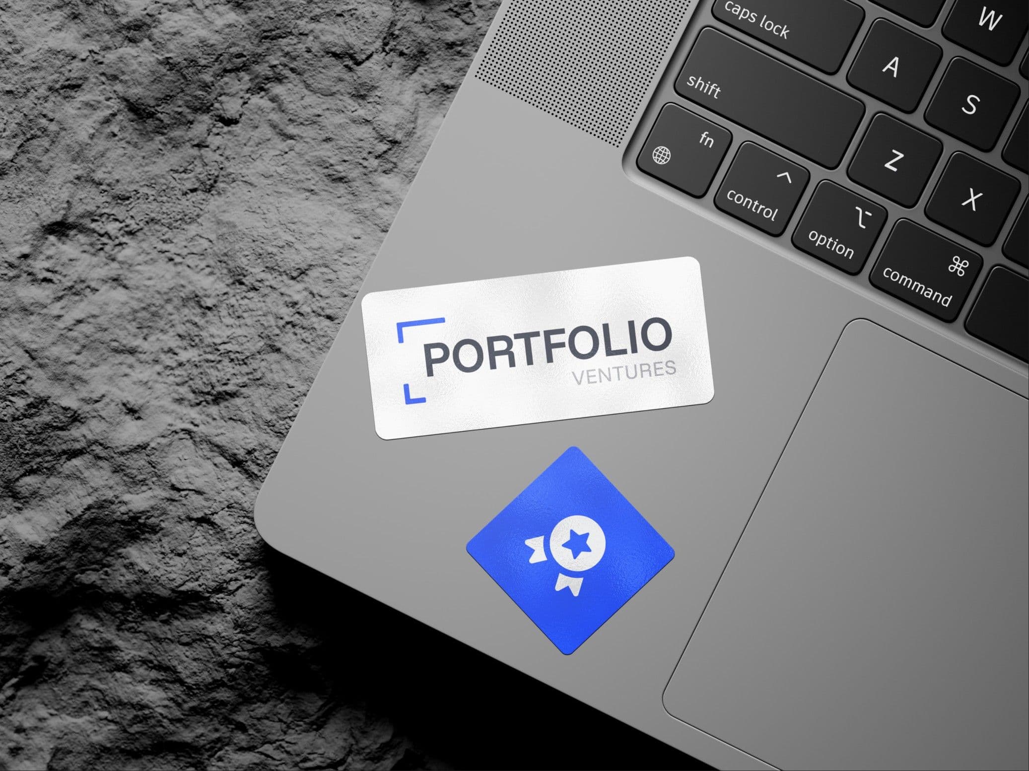 The PV mark on a sticker, on a laptop resting against rock